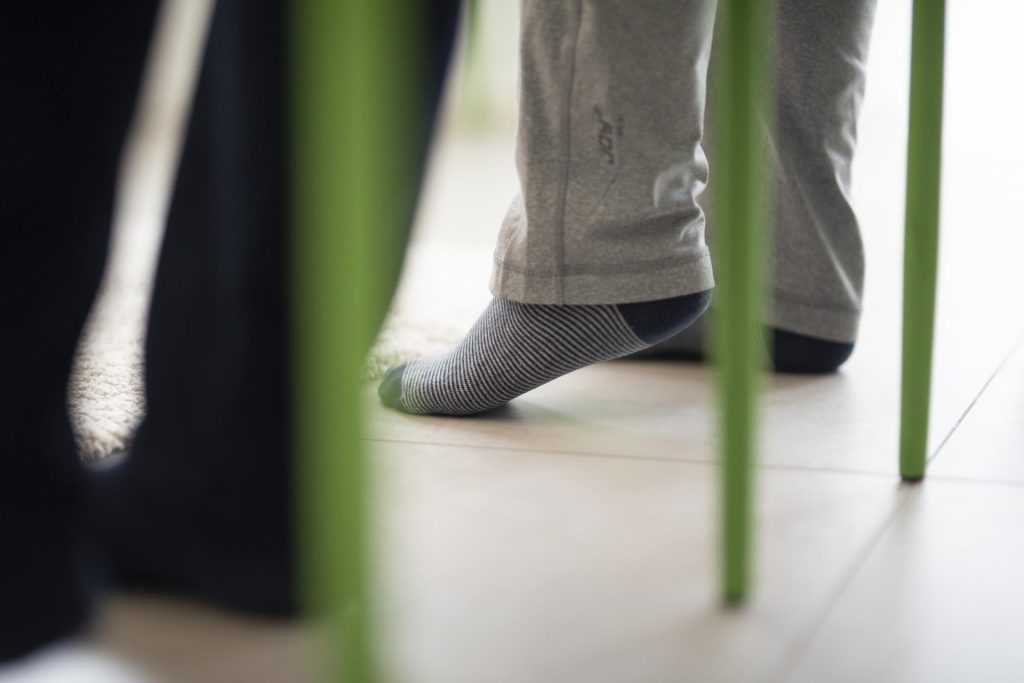 Füße unter einem Tisch